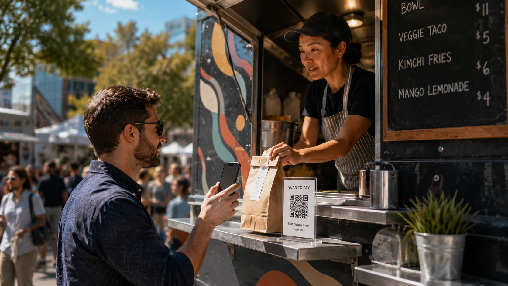 Food truck operator accepting a mobile payment from a customer at the service window